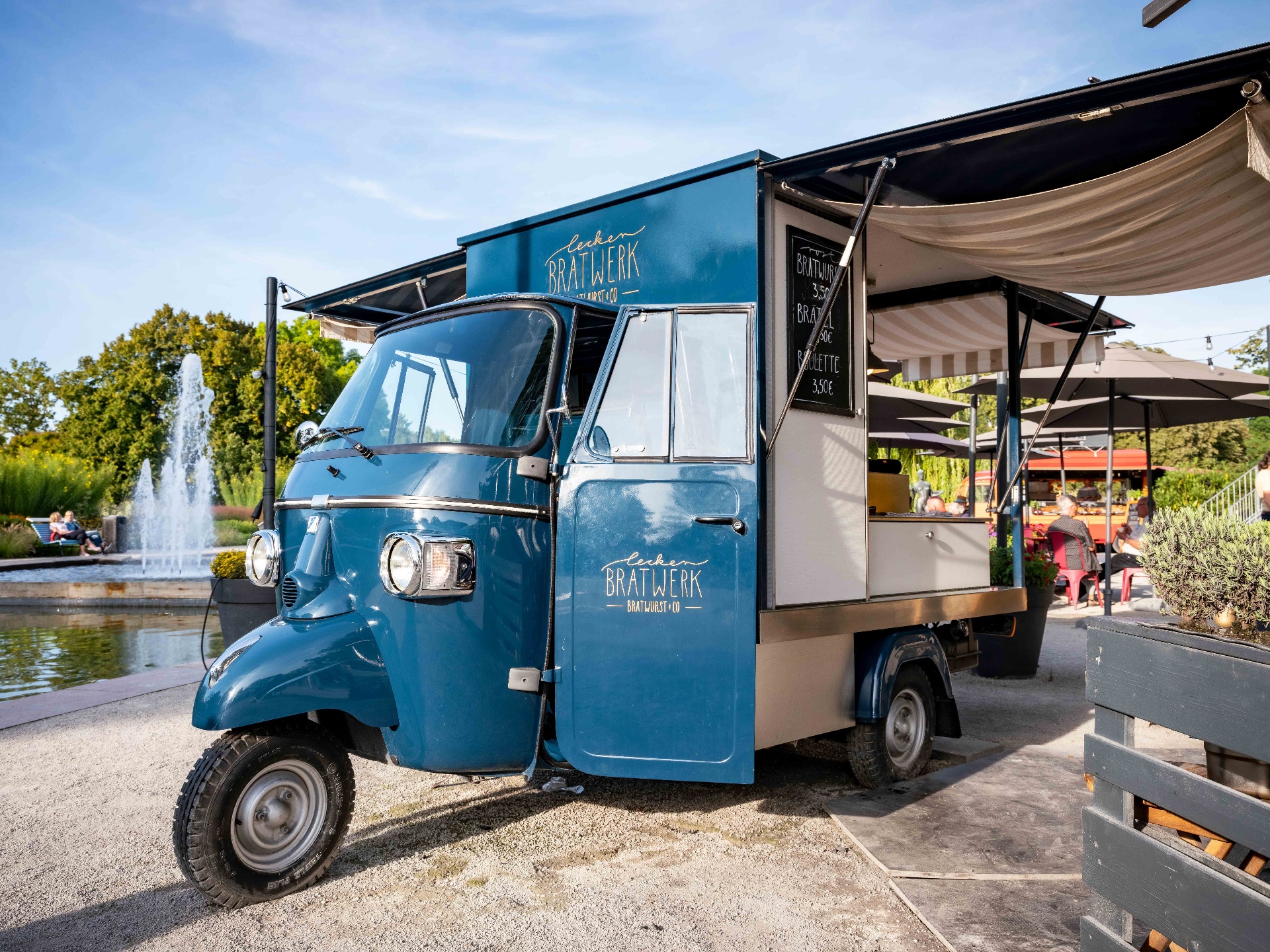 Dreirädriger Piaggio Ape Foodtruck in Vintage-Look mit Kaffeezubereitung auf einer Hochzeit